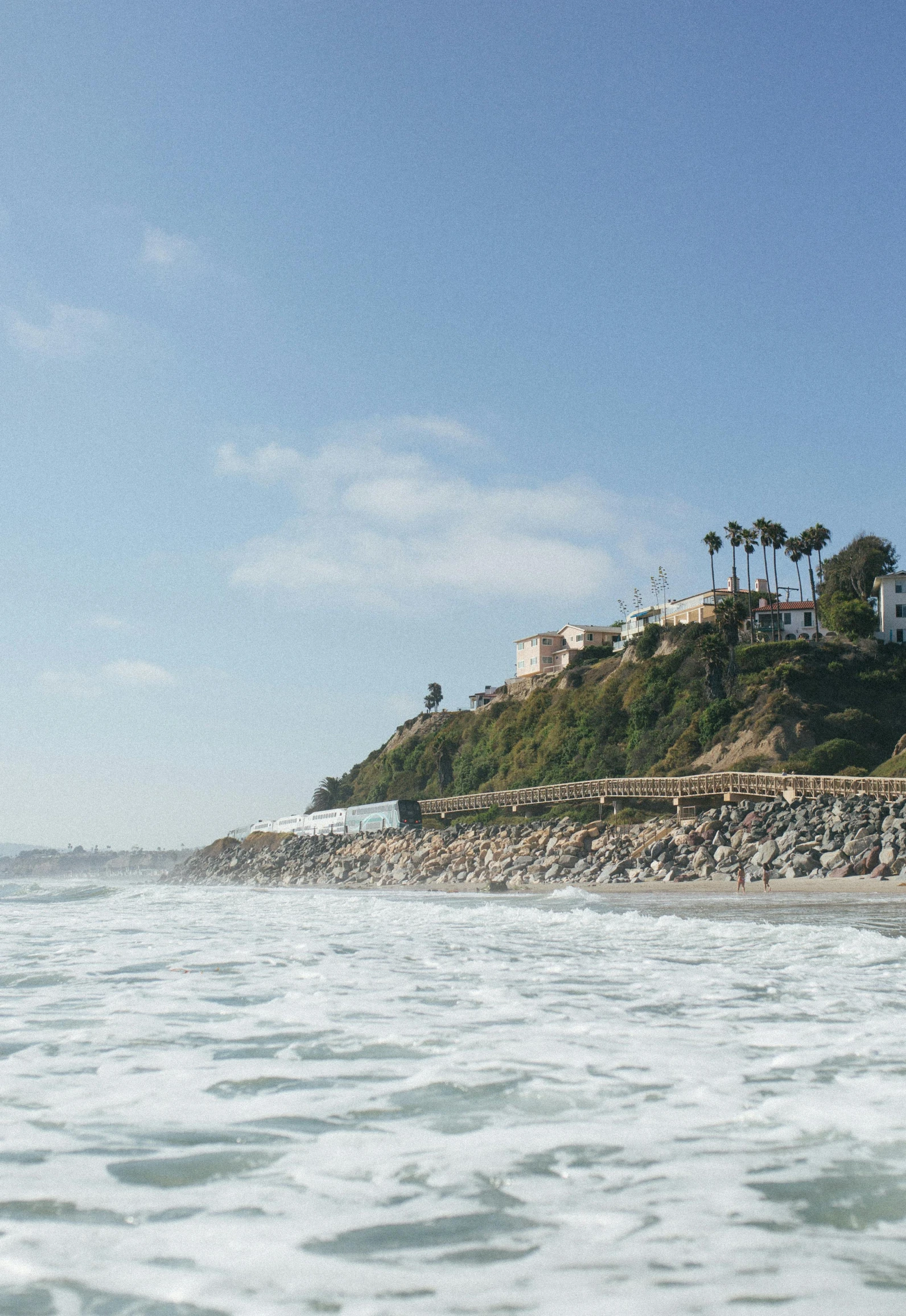 view of a sandy beach with lots of waves in front of some houses