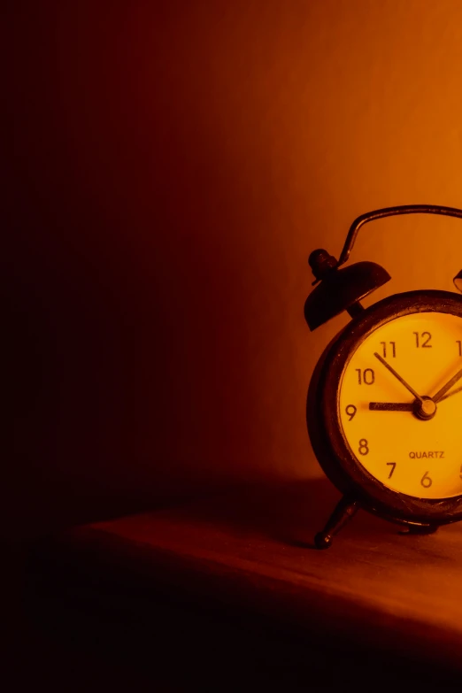 an alarm clock is glowing orange in a room