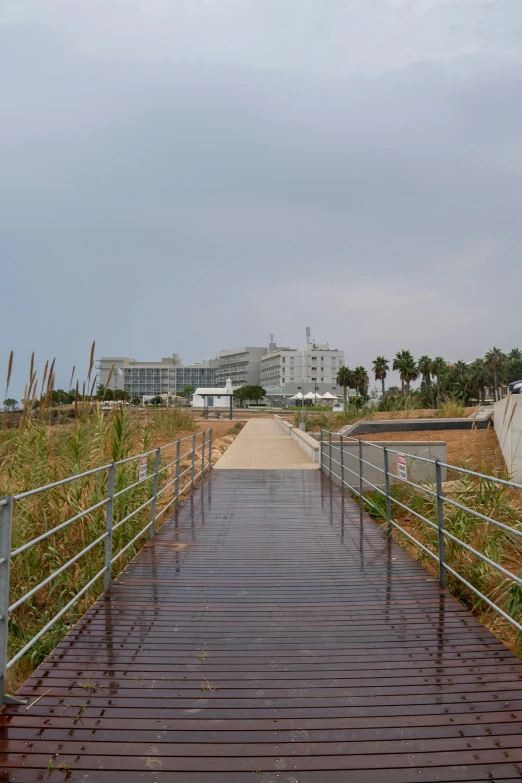 an empty wooden path in front of some very tall buildings