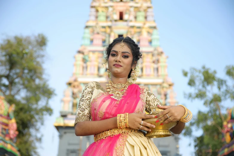 a woman dressed in a pink sari with a plate