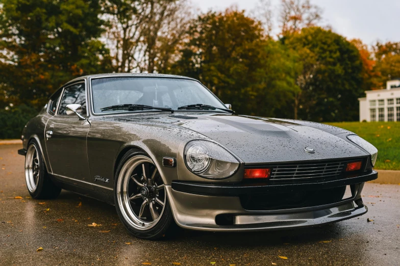 a silver and black mustang is sitting on a wet road