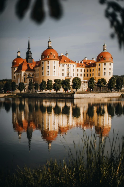 a lake in front of a large, old building