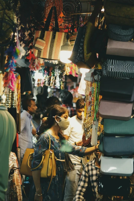 the people are walking through the colorful market