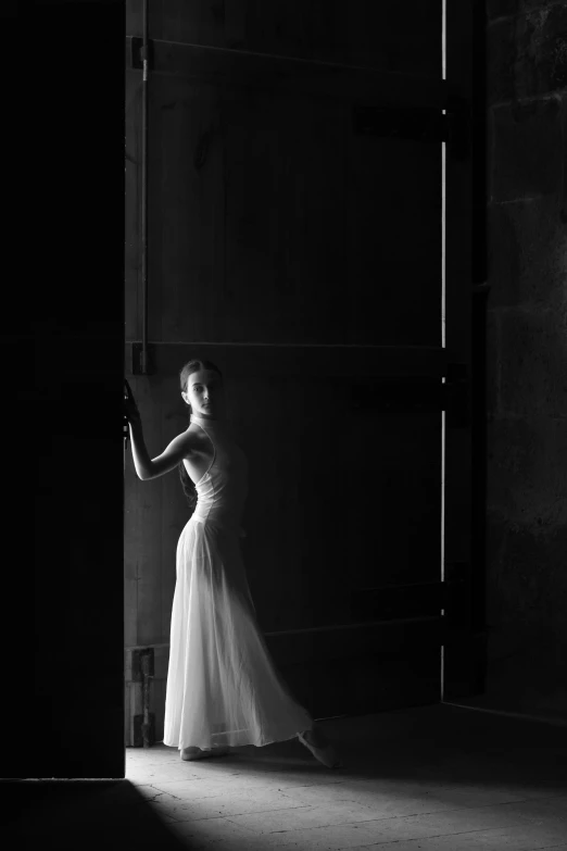 a beautiful woman in a dress holding onto the door of a building