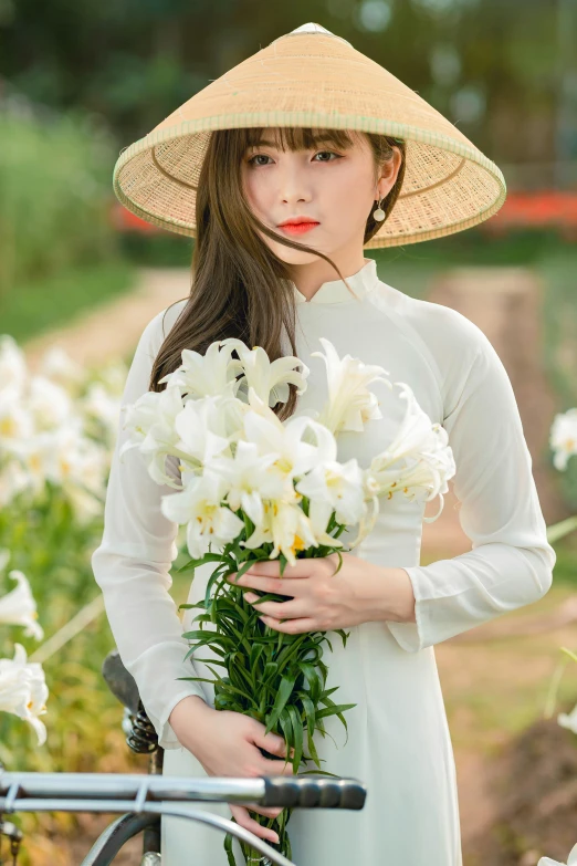 a woman holding a bouquet of flowers next to a bike