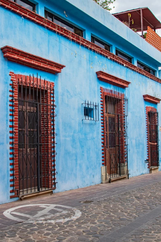 a blue building with iron bars on the side