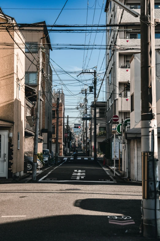 a quiet street lined with tall buildings under wires