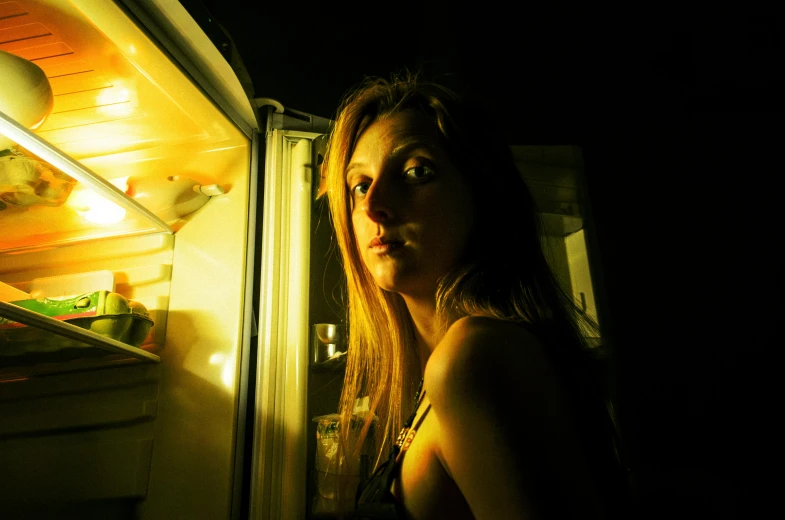 a woman standing inside a refrigerator filled with food