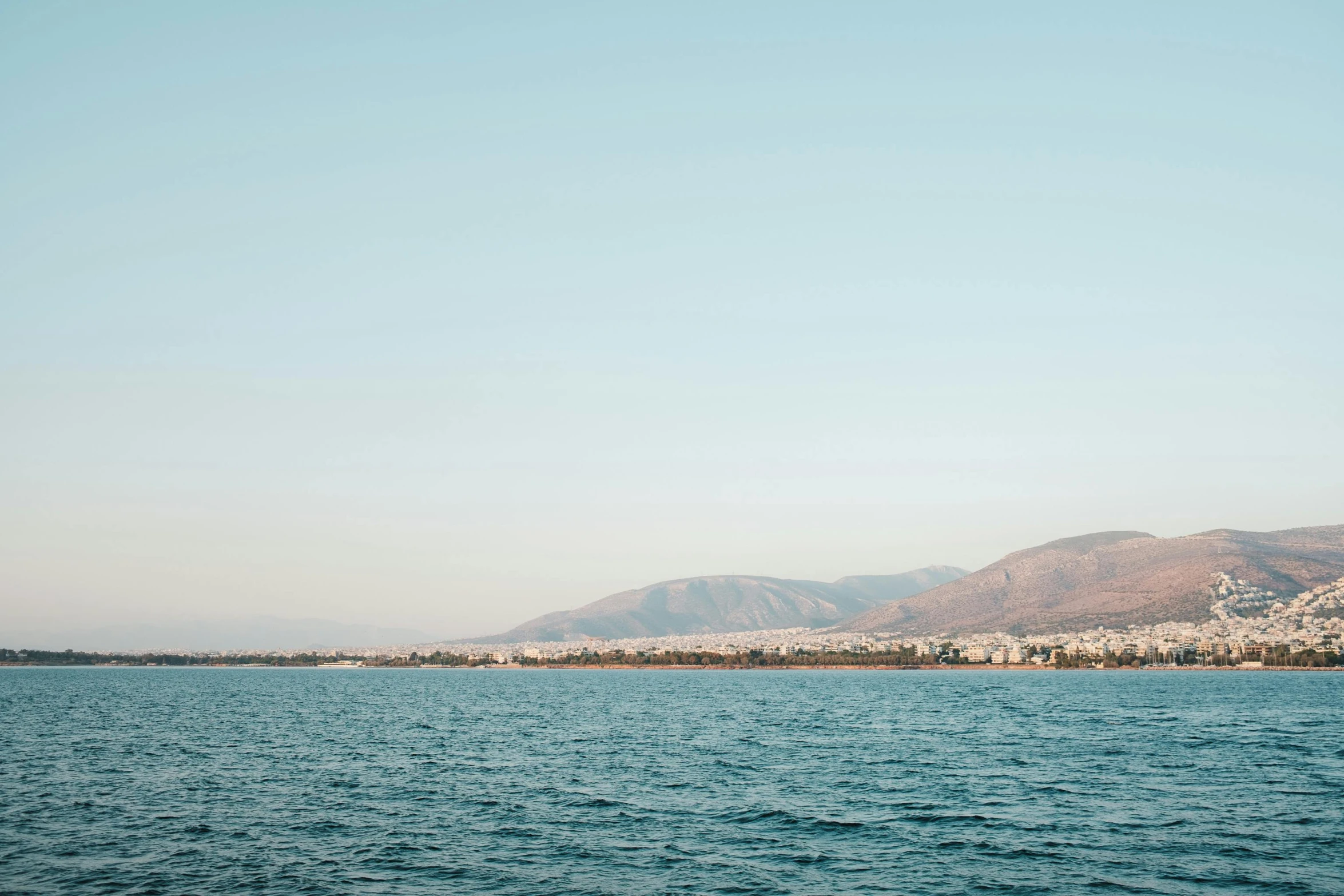 a boat in the ocean near some mountains