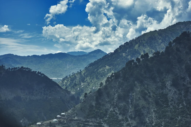 a view of mountains with clouds over them