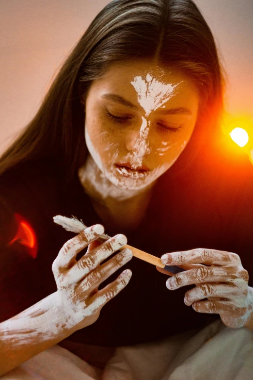 a woman with a white face paint and a cigarette