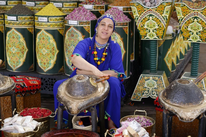 the woman is sitting on a bench surrounded by baskets