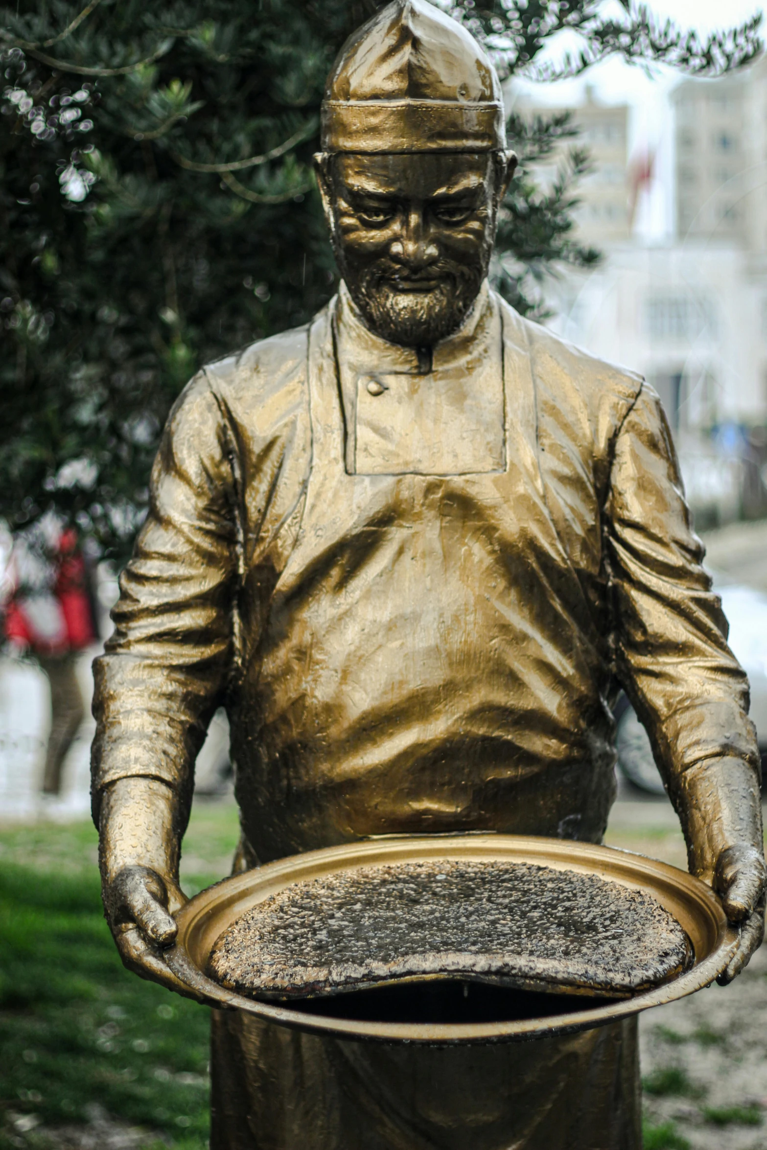 a statue of a man holding a round plate