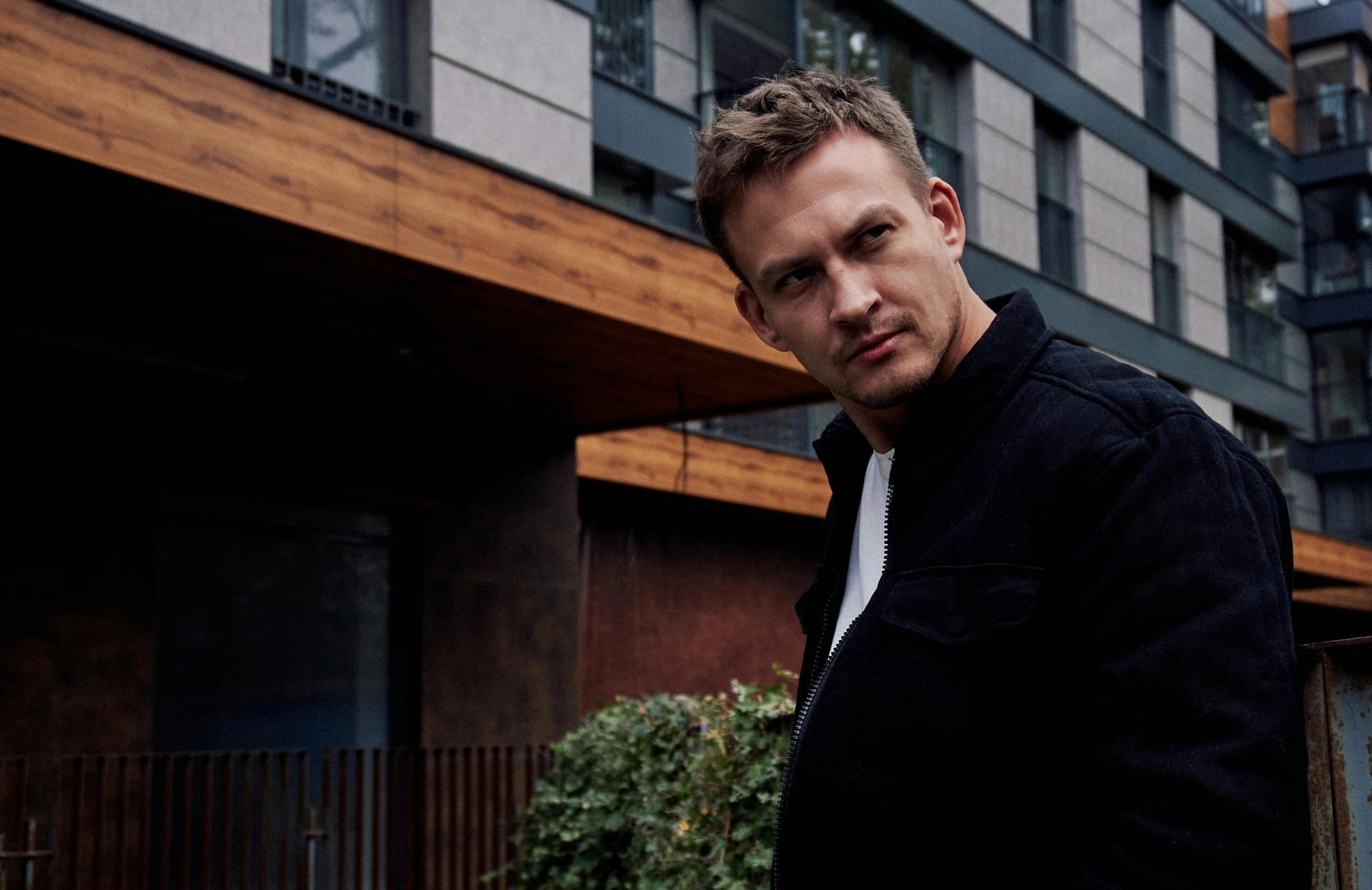 a man posing in front of a building