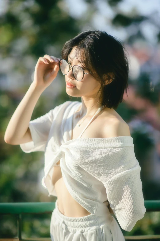 a woman wearing glasses while standing on a balcony