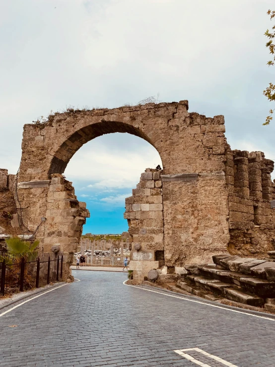 an old road going through some ruins, and through an archway