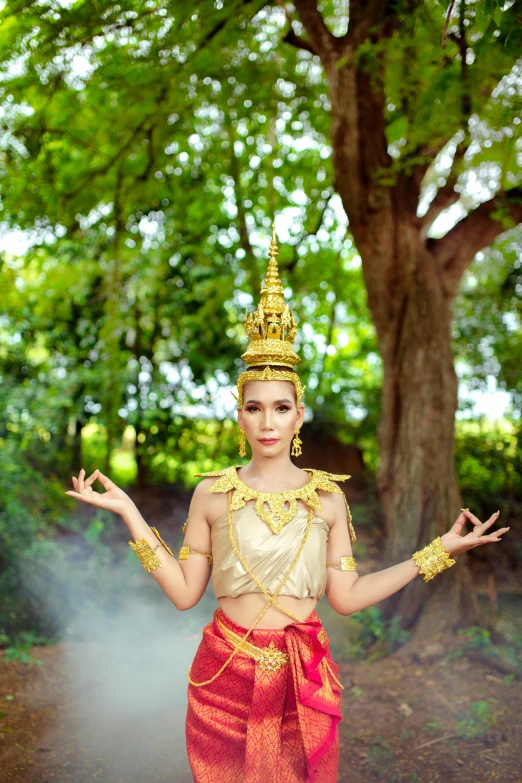 a young woman dressed in an asian style costume standing on dirt road