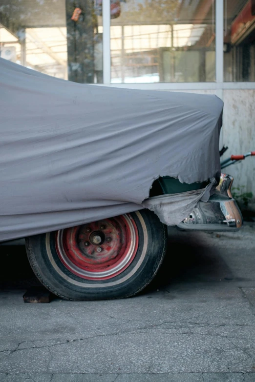 a car is covered up with gray cloth