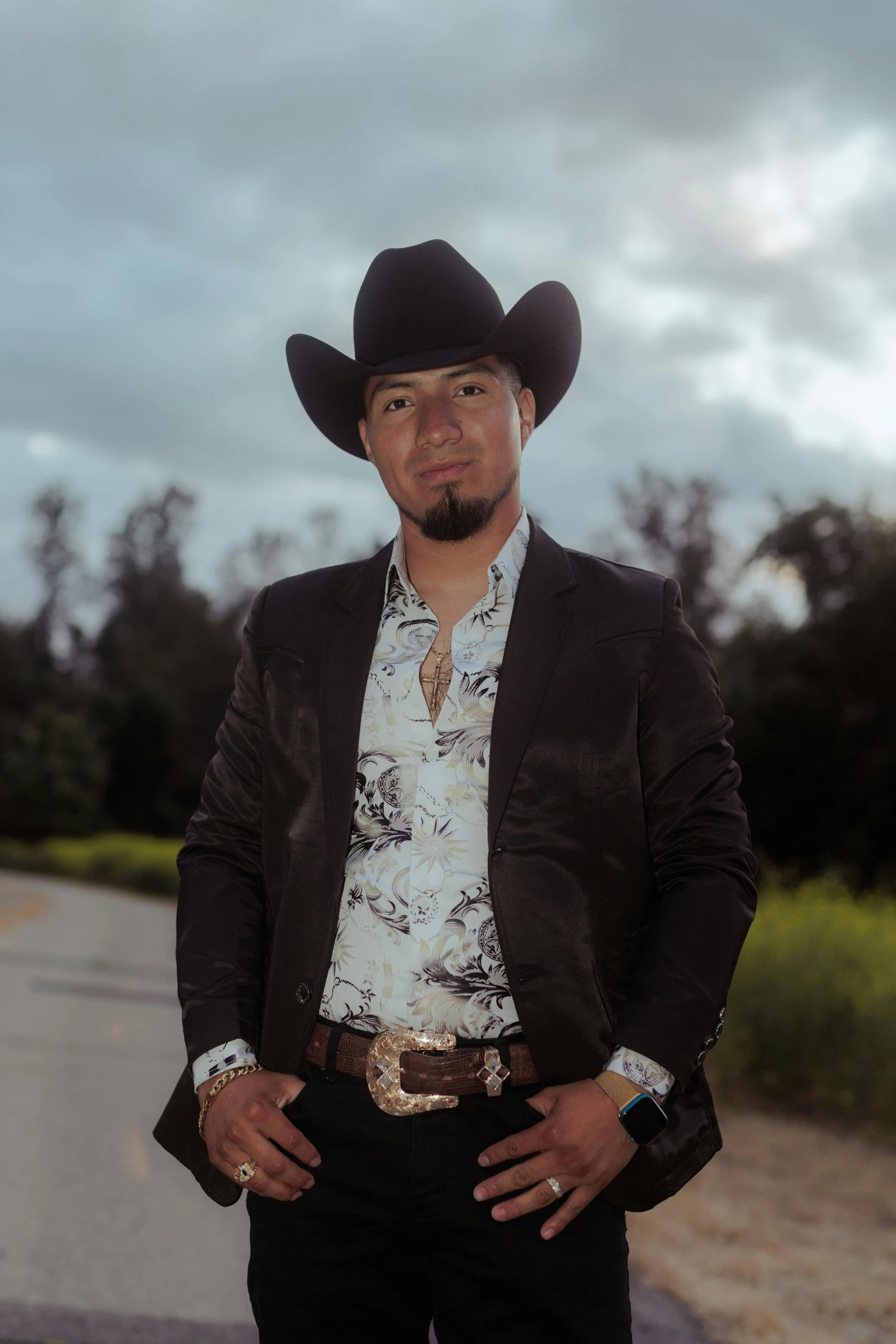 man with cowboy hat on his face standing on road