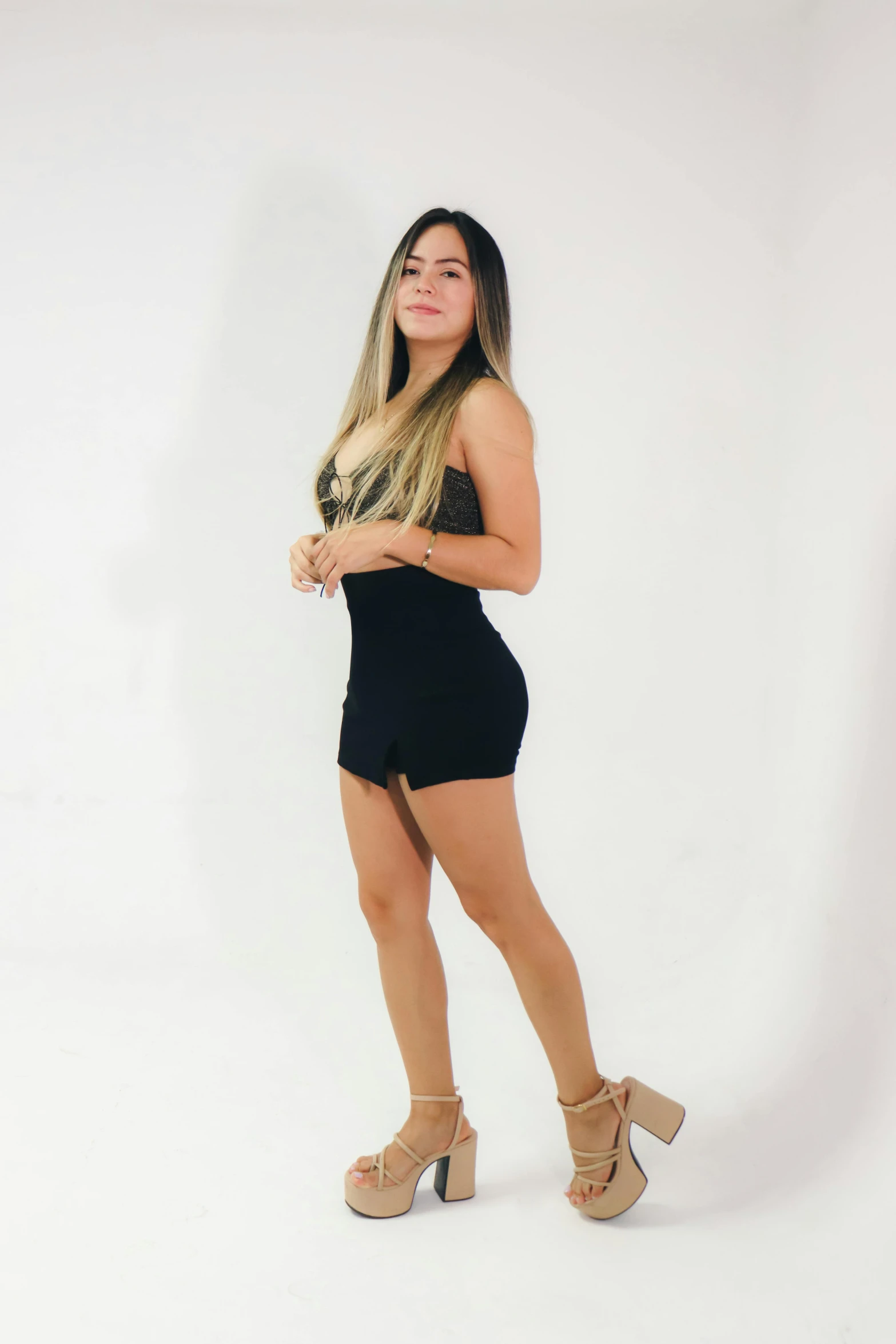 a girl in a black dress posing for the camera