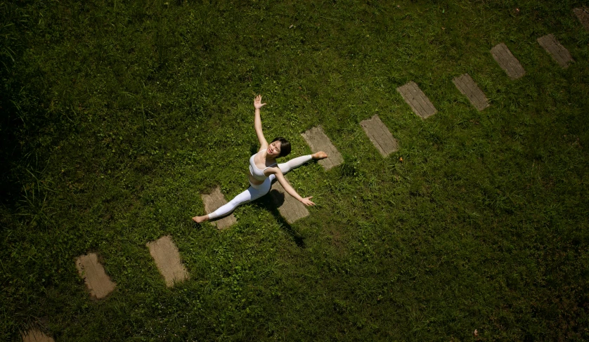 a young woman lays down in the grass