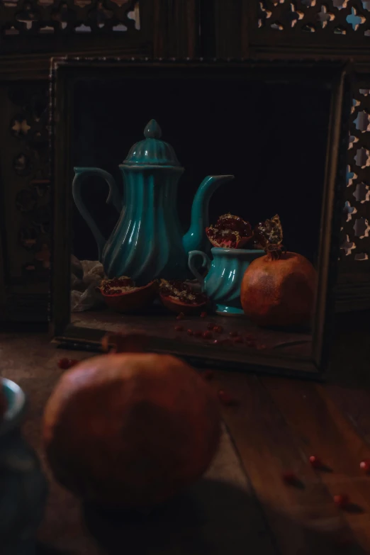 a vase and some apples are sitting in front of a mirror