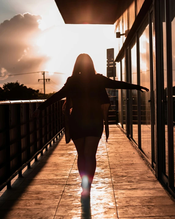 a woman is walking down a sidewalk while holding her arm on her hip