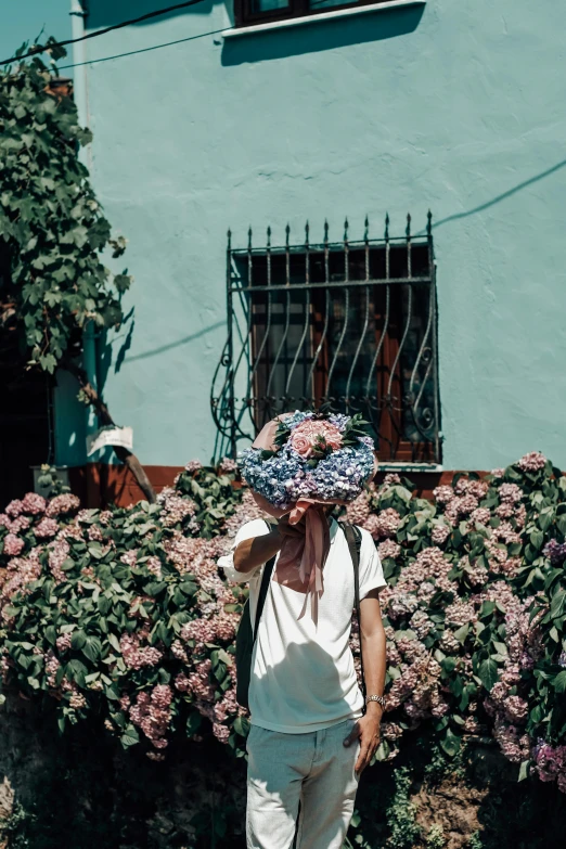 a woman is walking on the side walk by flowers