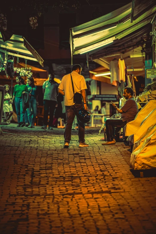 a man standing in front of a market selling banana's