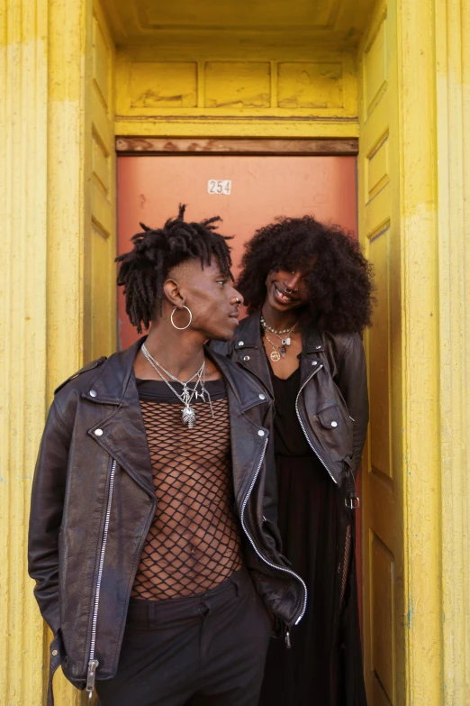 two black people standing on the corner of a building