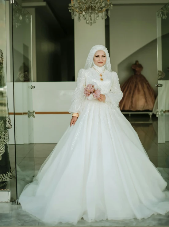 a woman in white dress standing near a large glass wall