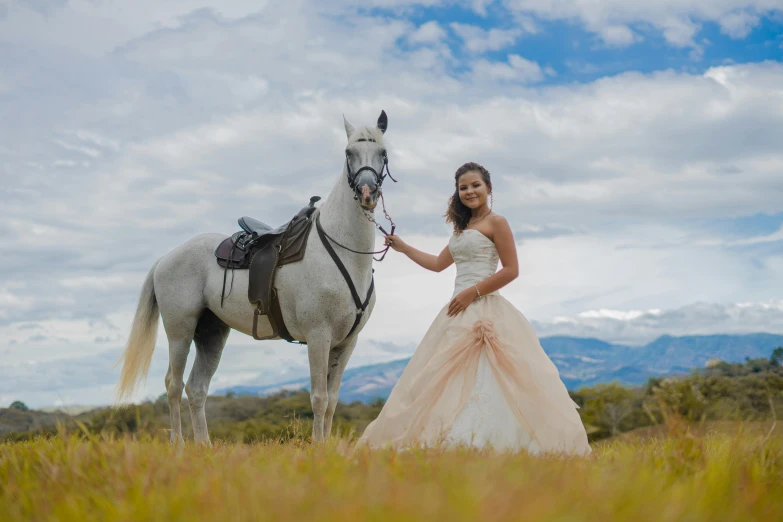 a woman holding a white horse in a grassy field