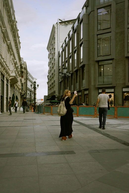 a person takes a picture in front of a large building