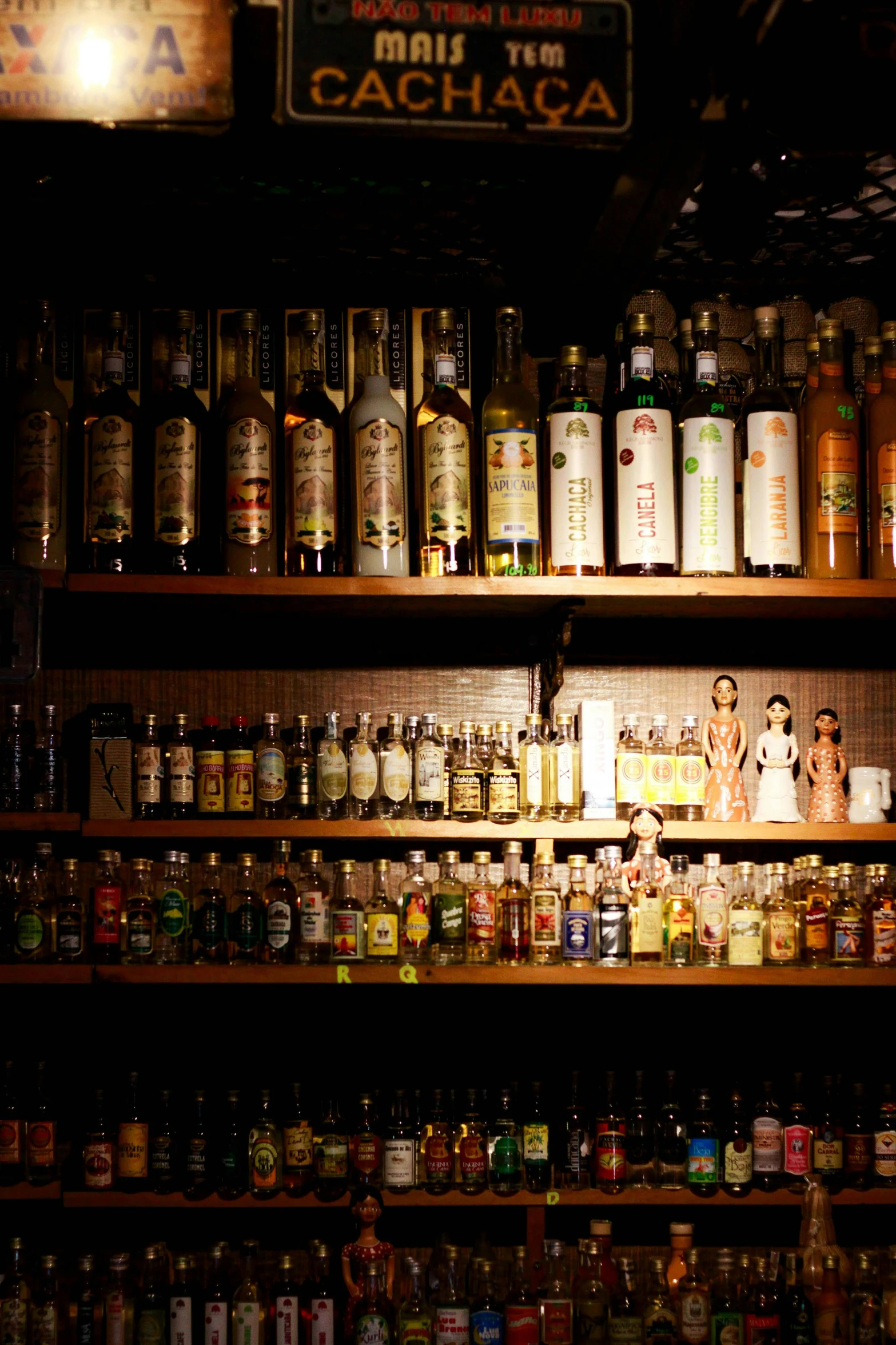 many bottles are lined up on the shelves of a restaurant