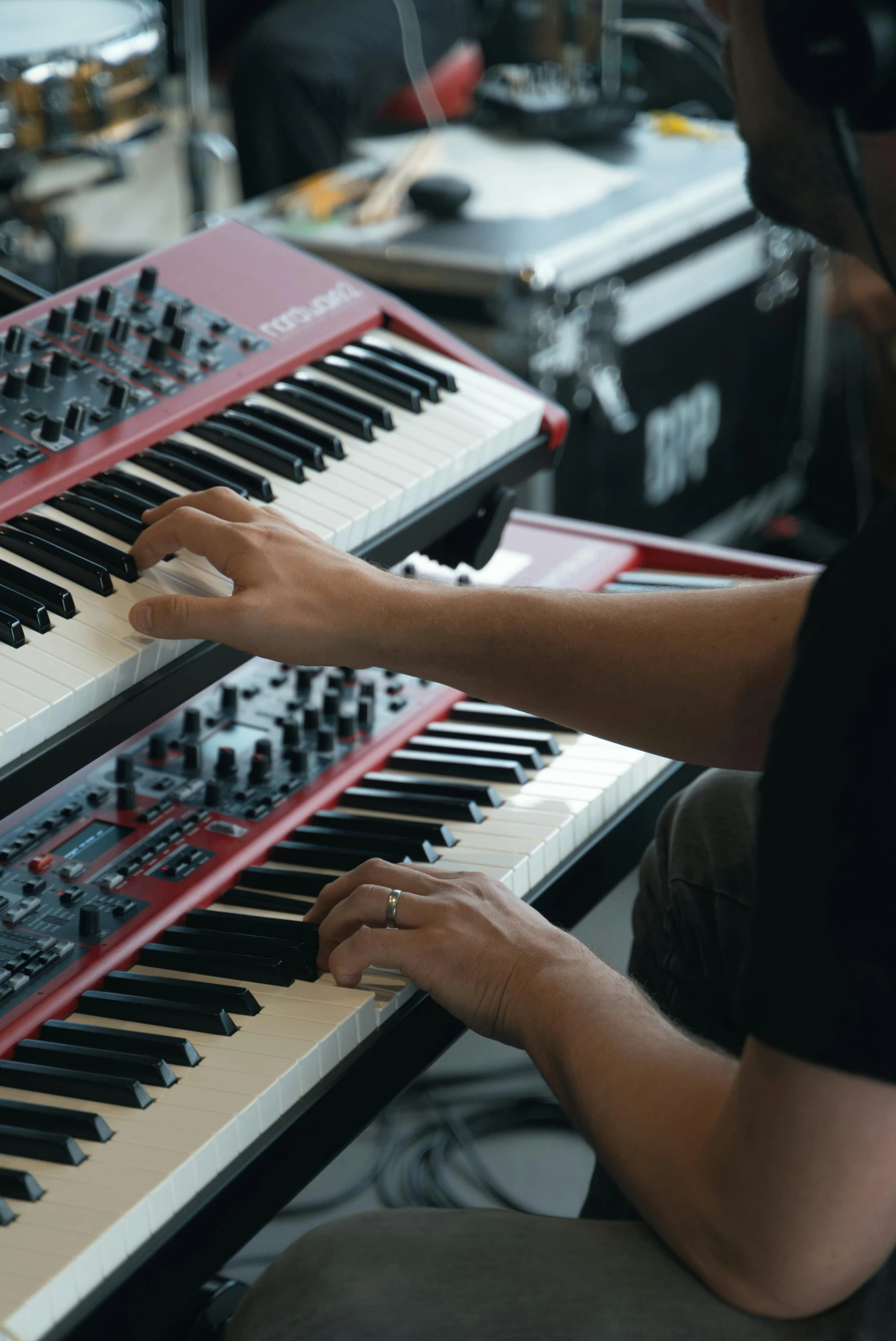 a man is playing the organ keyboard while sitting in front of two monitors