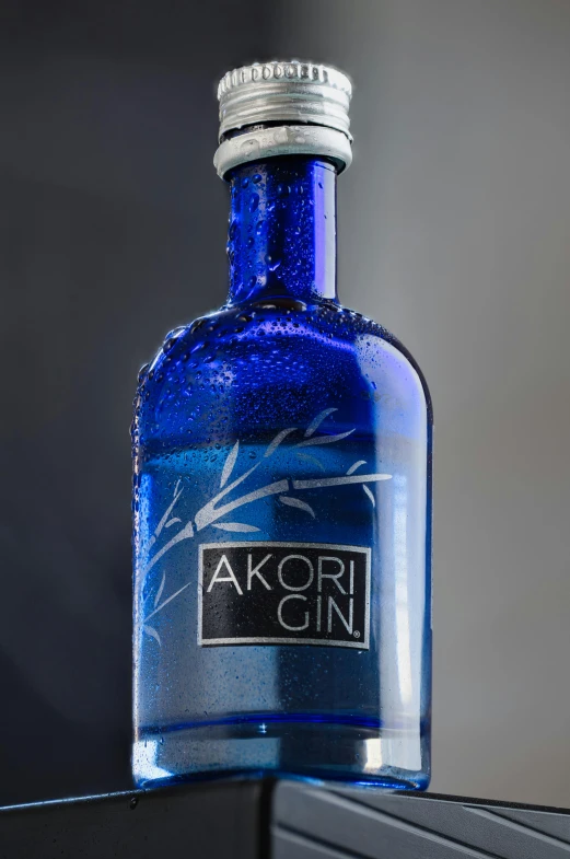 a blue bottle of alcohol with a small sticker on top of it