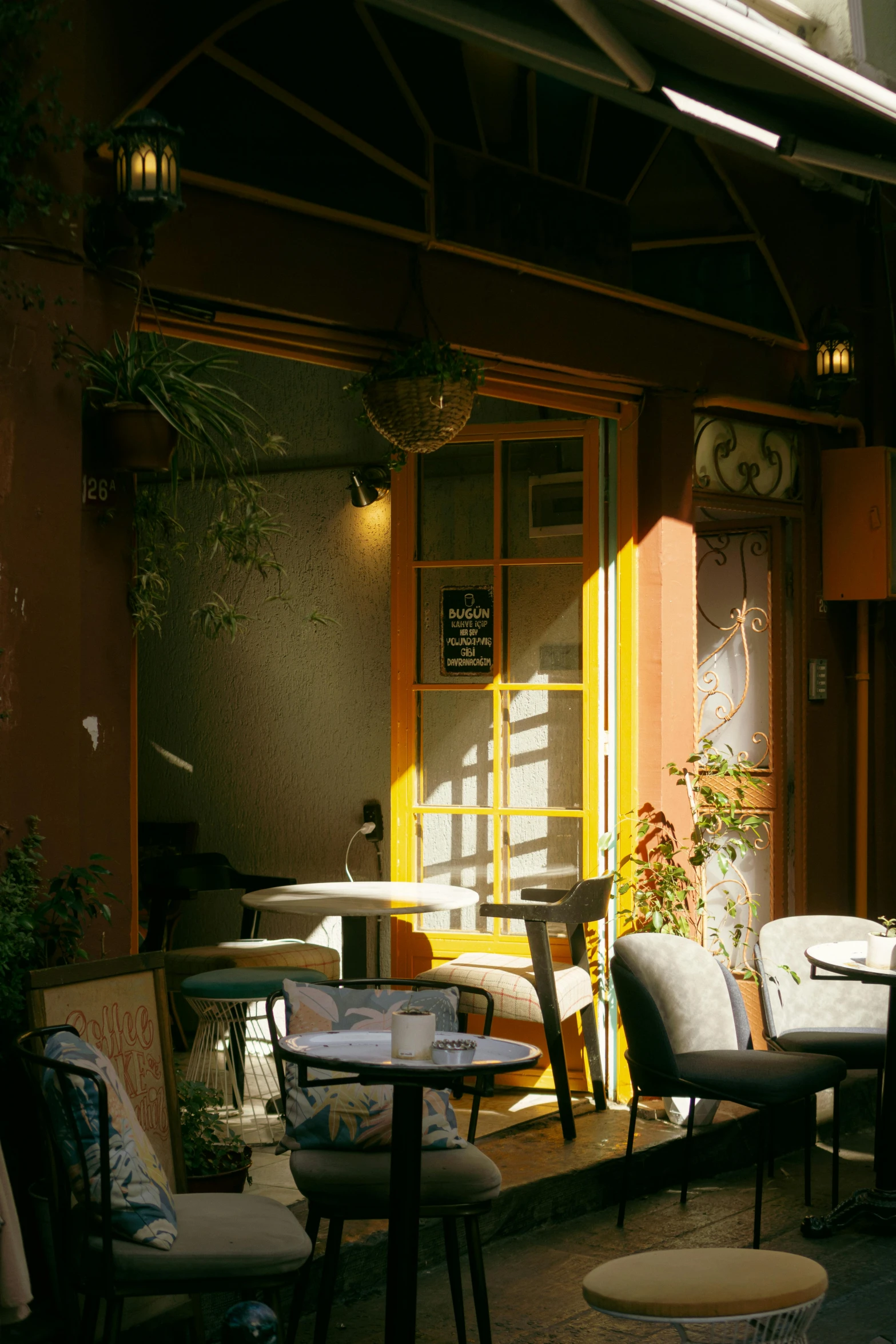 a patio with several tables and chairs and a few plants