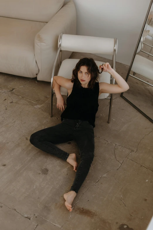 a woman sitting on the floor in front of a chair