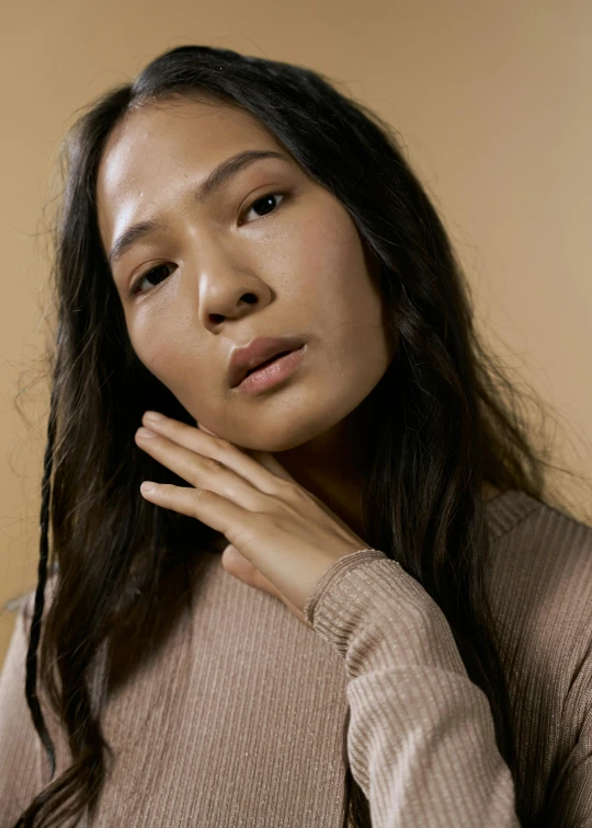 a woman with long hair and a sweater is posing for the camera