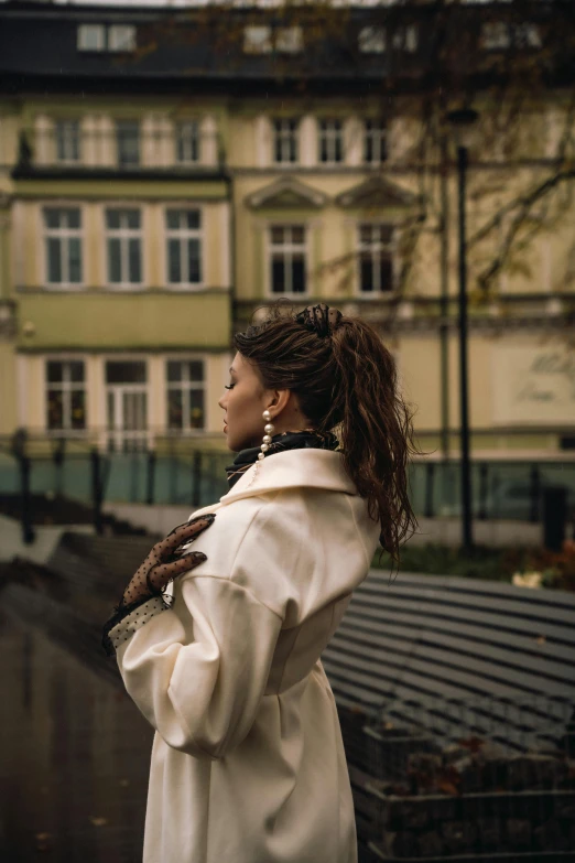 the woman is standing outside of a large building