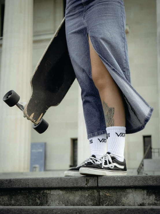 a person wearing black tennis shoes and gray pants with his foot on the ground