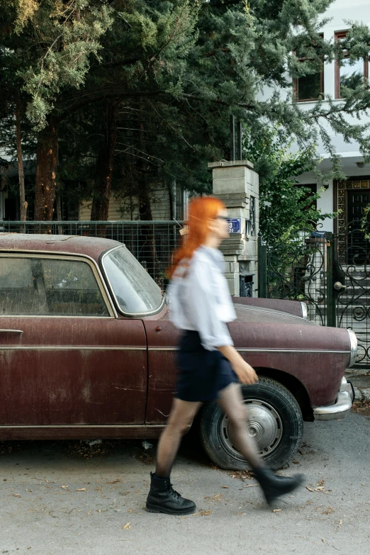 a person is walking past a car on the street