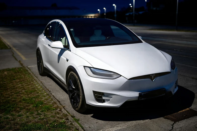 a white car parked in a parking space with a dark sky