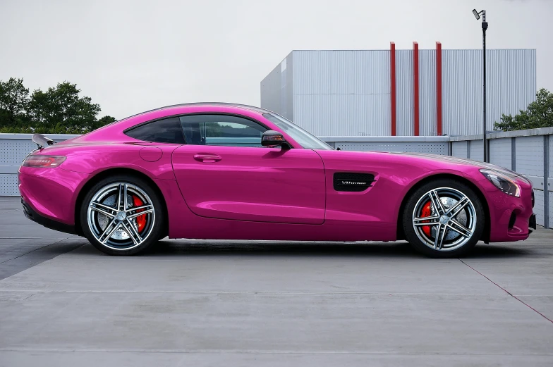 a very pink mercedes sls parked in front of a building