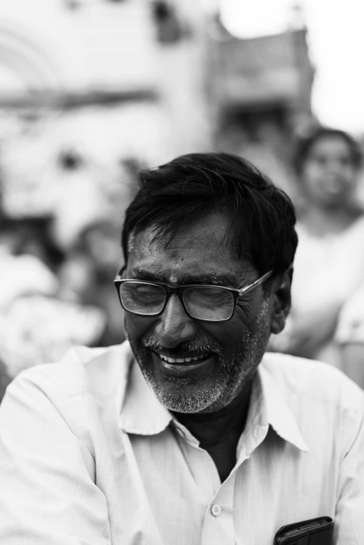 a man wearing glasses looking at his cell phone