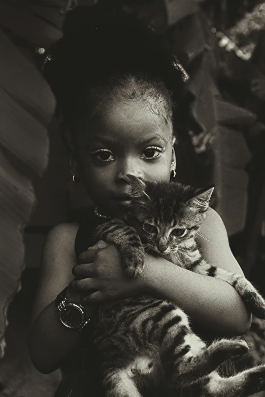 black and white pograph of a little girl hugging a cat