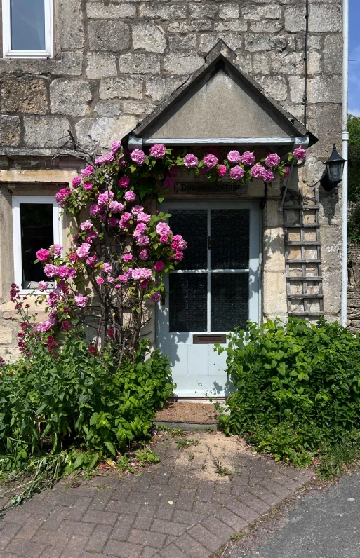 a small house with flowers in a front garden