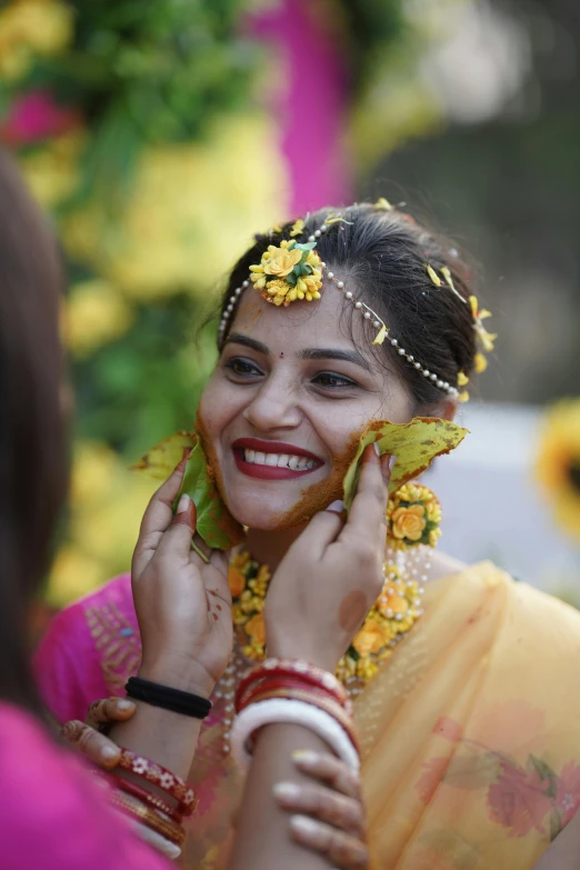 a woman smiles while she poses for a po with her face covered