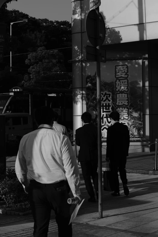 a group of people on sidewalk next to a building