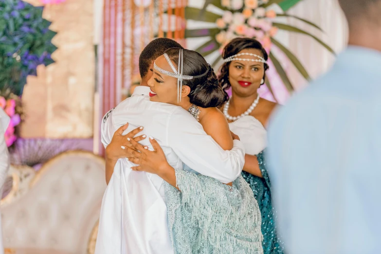 two women hug each other at a wedding